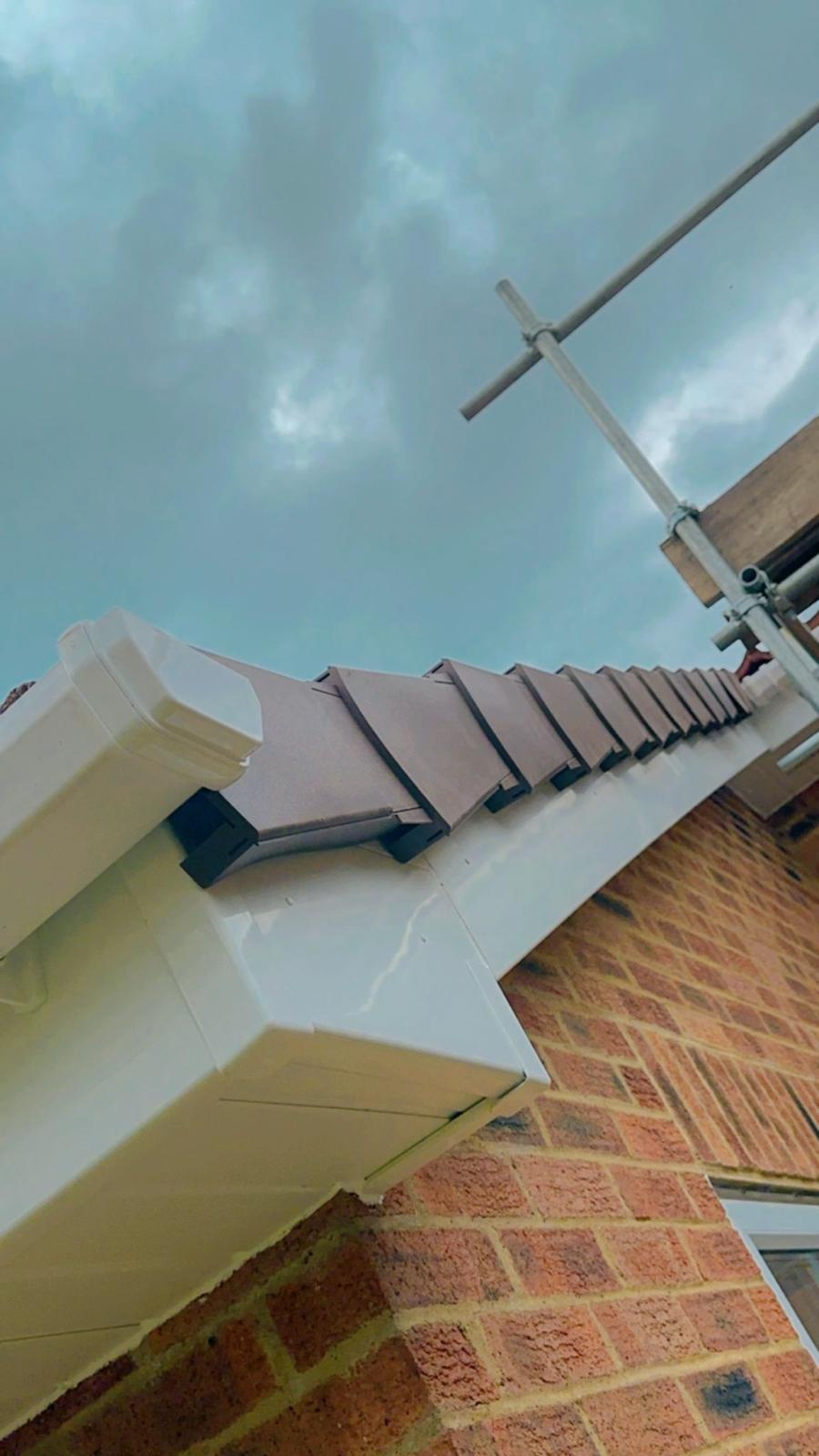 Slate roof installation with ridge tiles